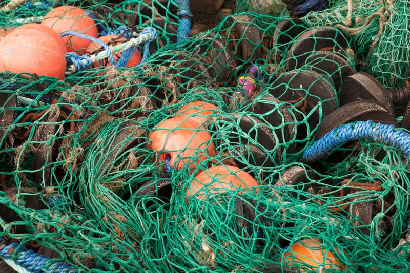 Photo of a pile of fishing near with nets, hoppers and bouys