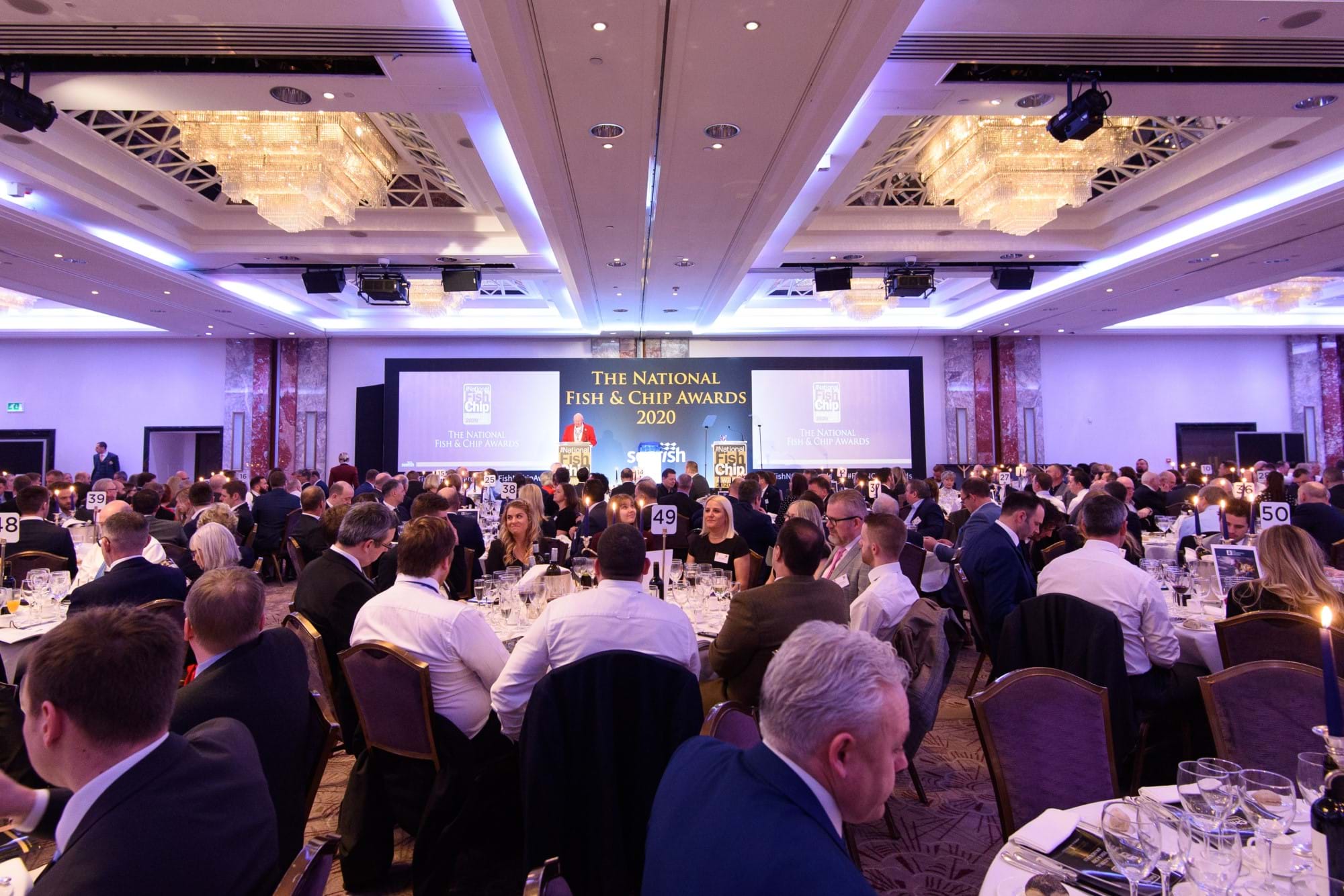 Photo showing lots of people sat around tables in front of the stage at the National Fish & Chip Awards ceremony in January 2020.