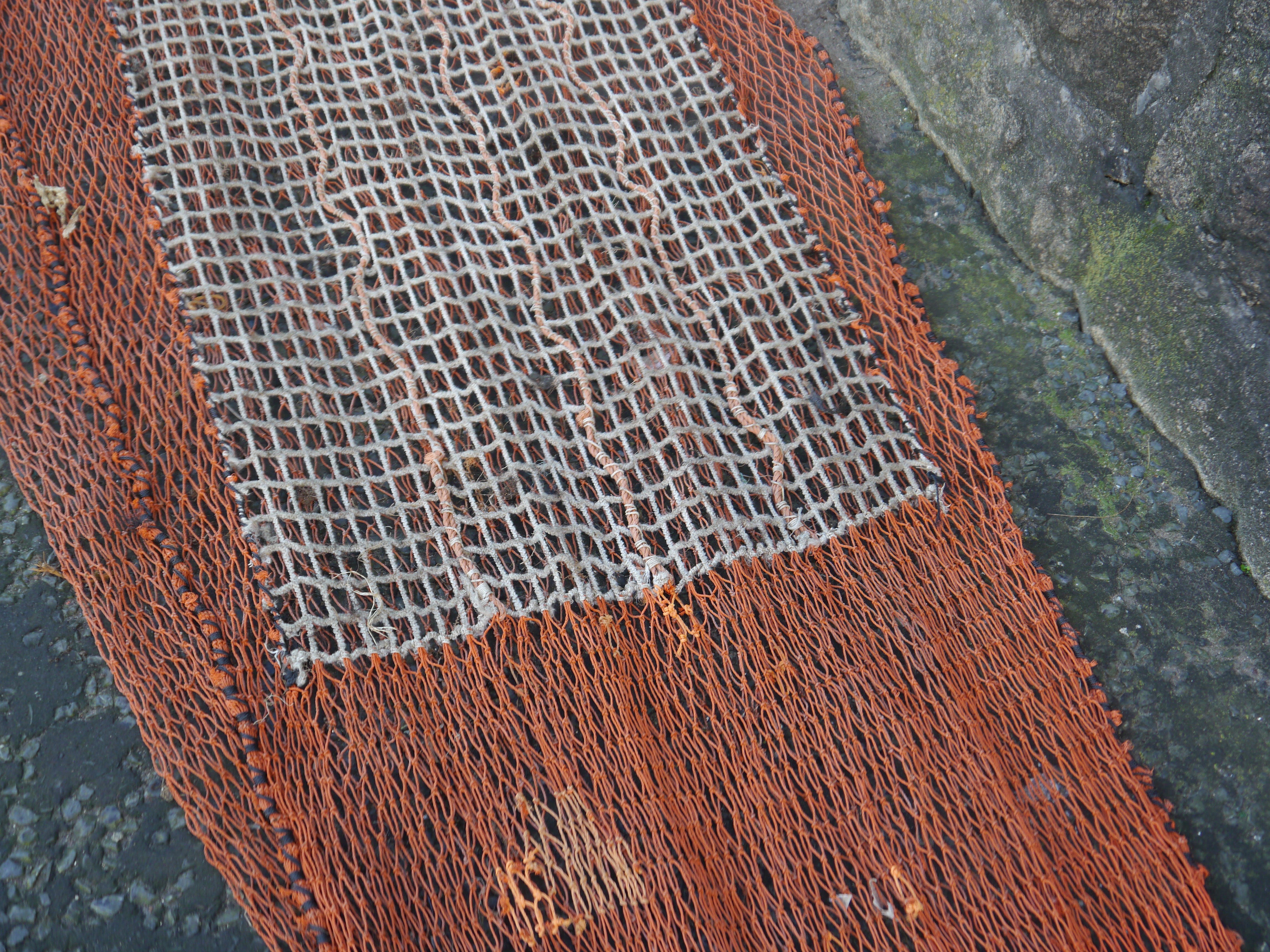 A section of diamond netting removed and replaced with a square mesh panel