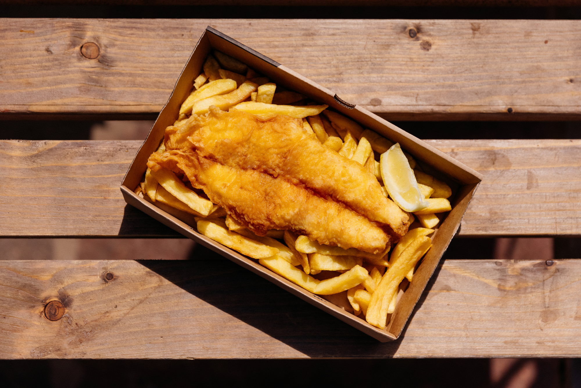 Photo of a portion of fish and chips in a takeaway box