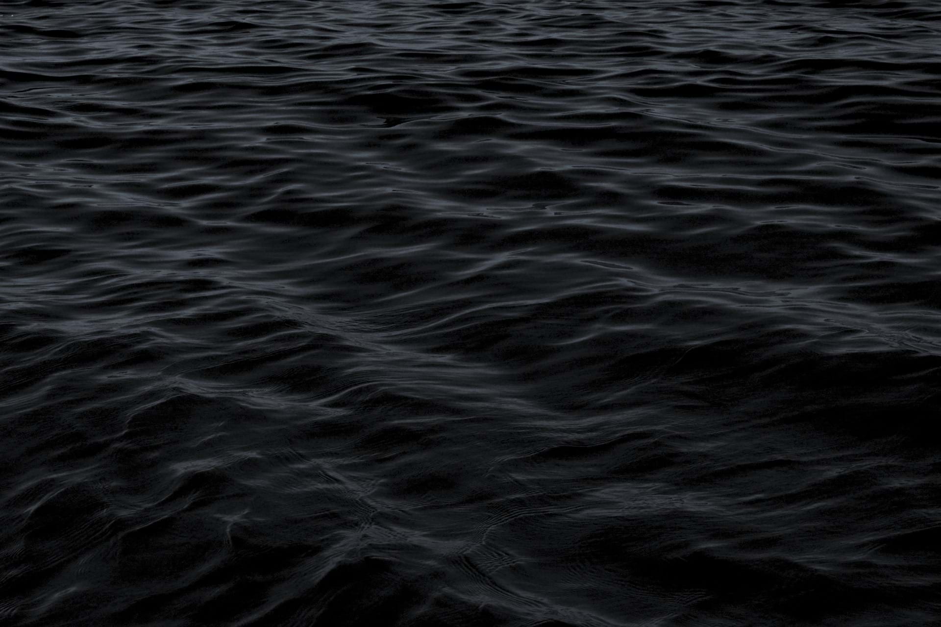 Photo of small waves at sea in the dark