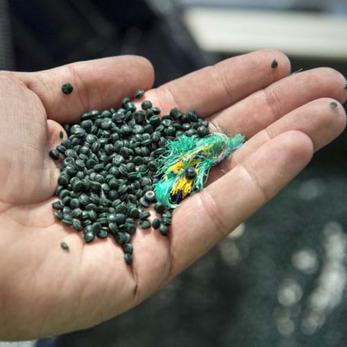 Photo of small pellets of recycled plastic in hand