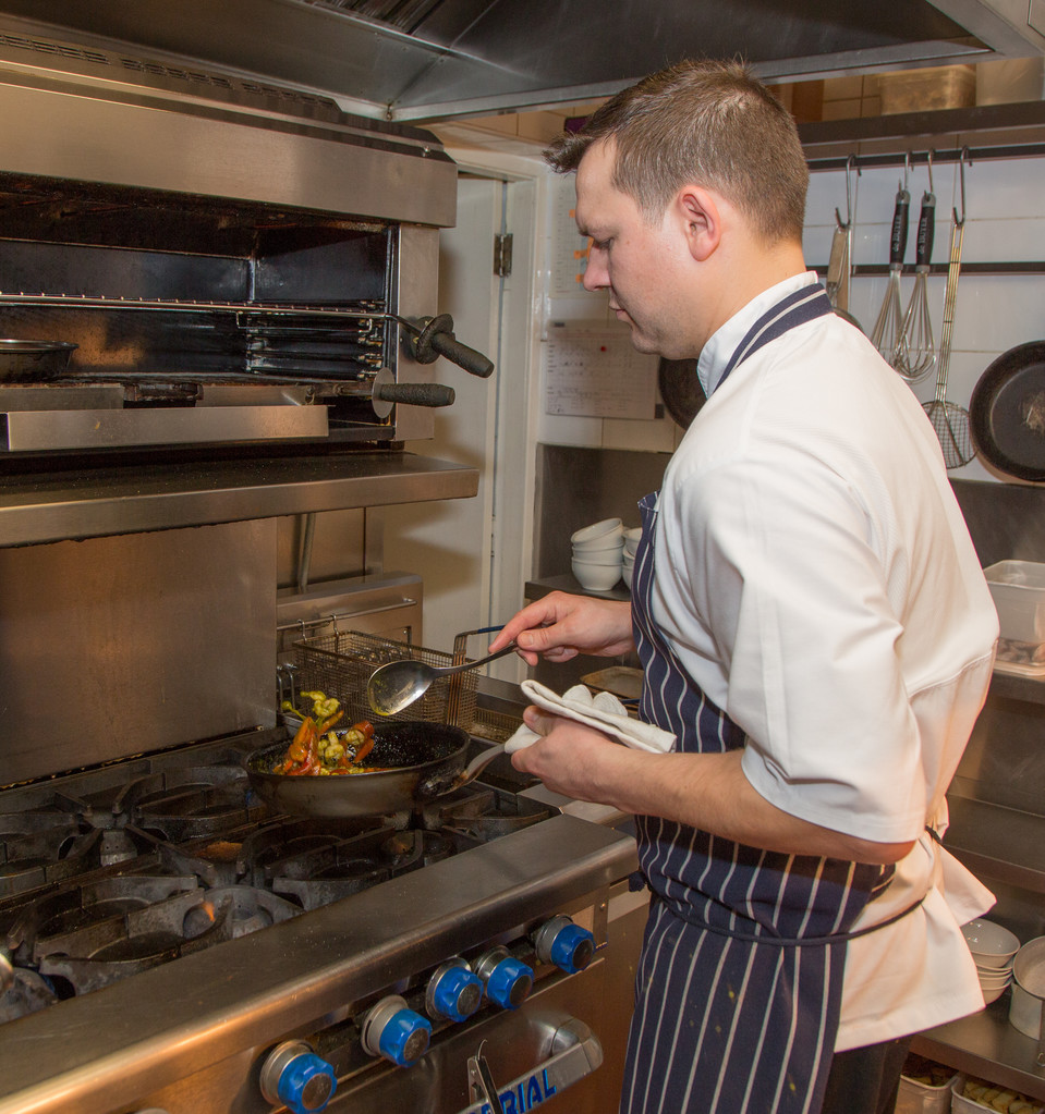 A chef preparing a dish in a kitchen