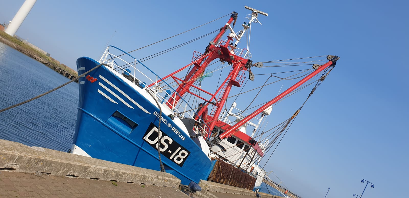 The Cornelius Blyth trawler docked at a harbour.