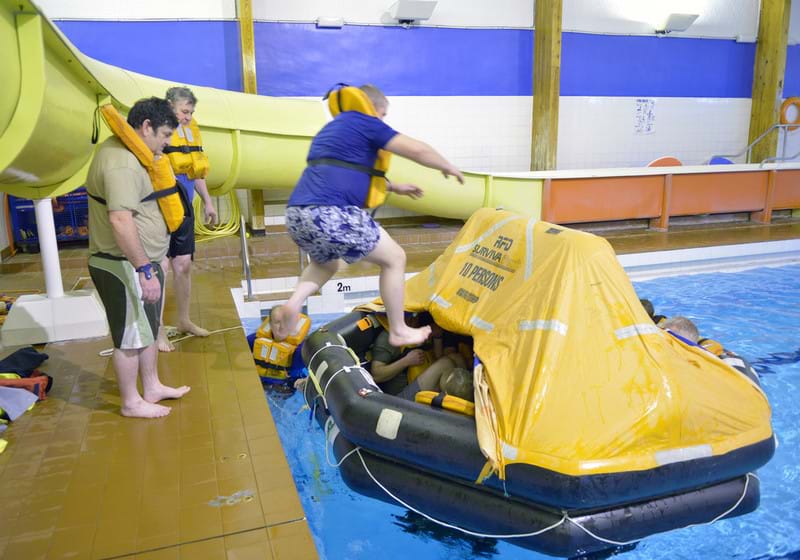 Course participant jumping into liferaft