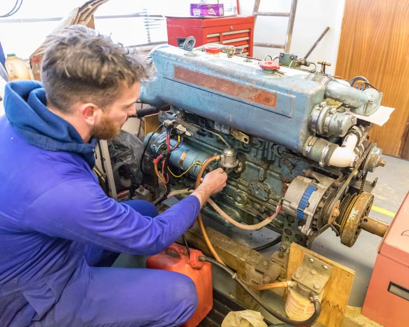 A man is working on an engine from a fishing vessel as part of a training course.